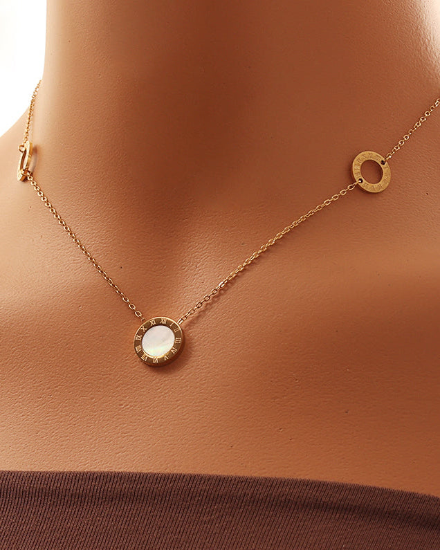 Persona con collar fino dorado de tres motivos circulares, con centro blanco nacarado y bordes dorados.