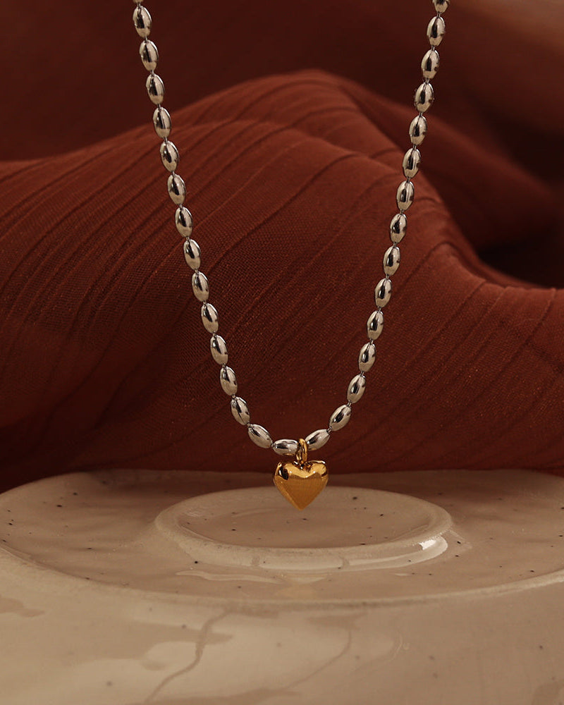 Detalle de collar Corazón Enlazado con acabado dorado