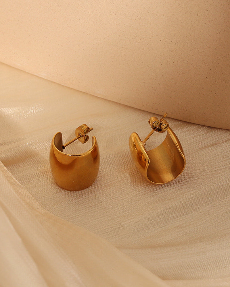 Detalle de aretes Solar con acabado dorado